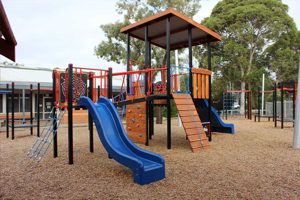 Main Fortitude combination unit with twin slides and timber climbing wall at Heany Park Primary School playground.