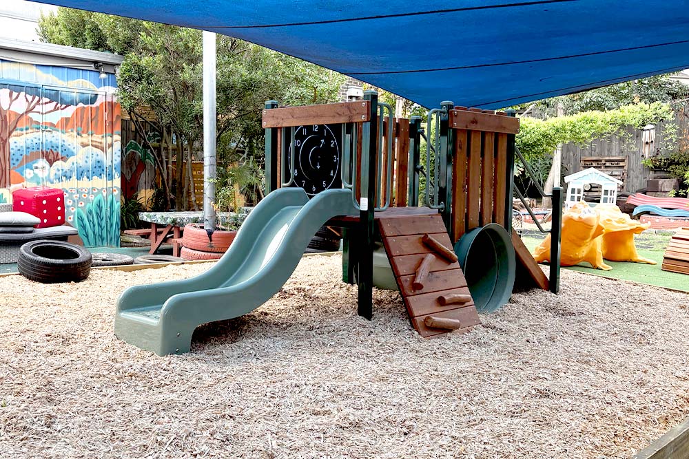 Wonderland Early Learning Doncaster playground with timber play structure, double slide, climbing wall and tunnel