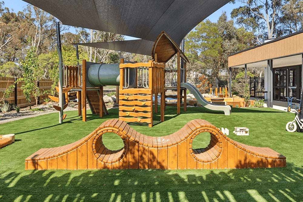 Gumboots Early Learning Centre playground in Gisborne with timber climbing equipment, slides and nature play elements